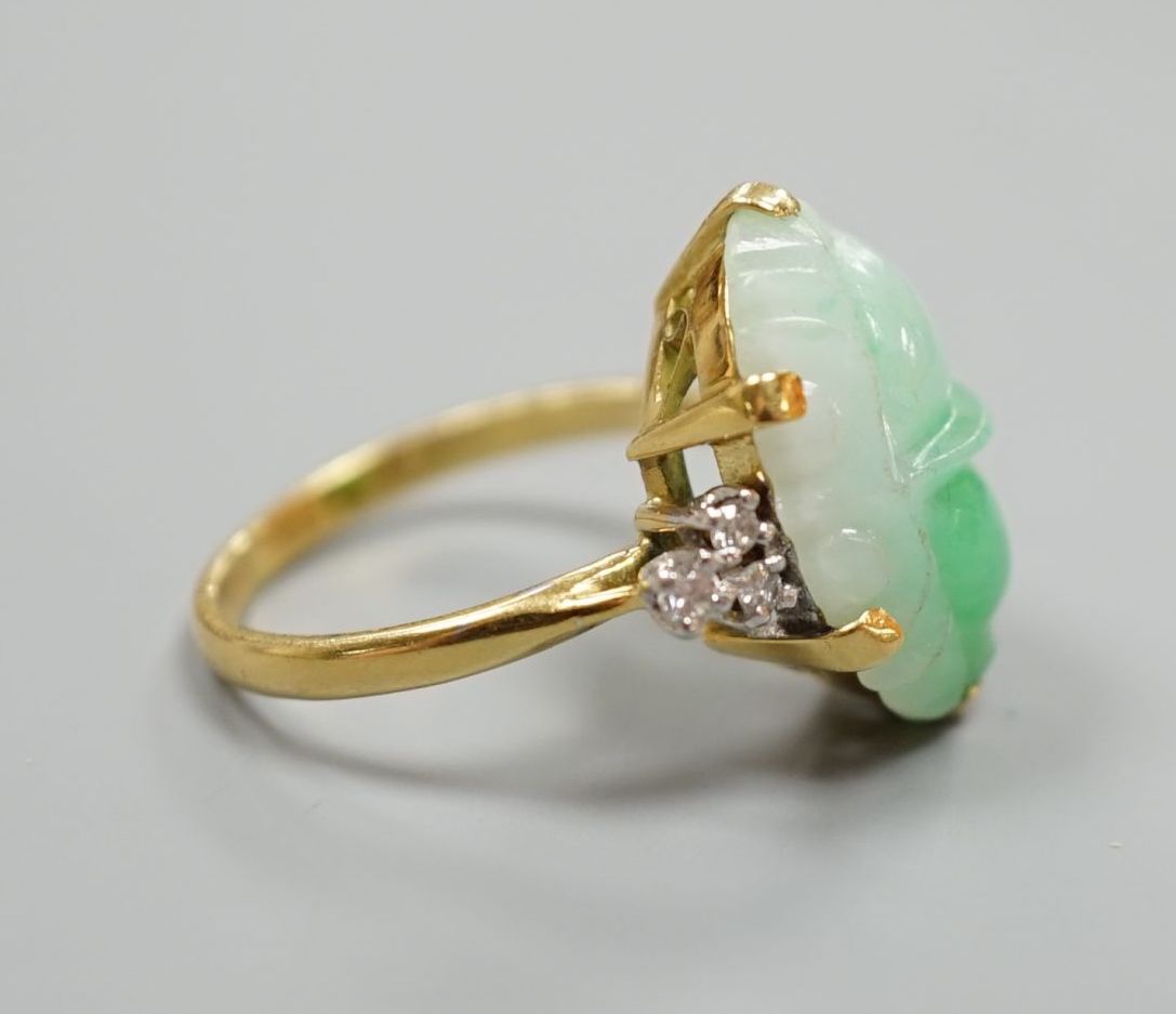 An 18ct, carved jade cabochon and diamond set oval dress ring, size O, gross weight 6.2 grams.
